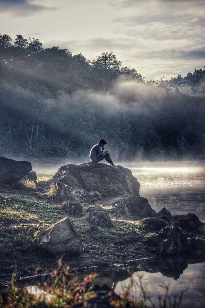 man sitting on rock
