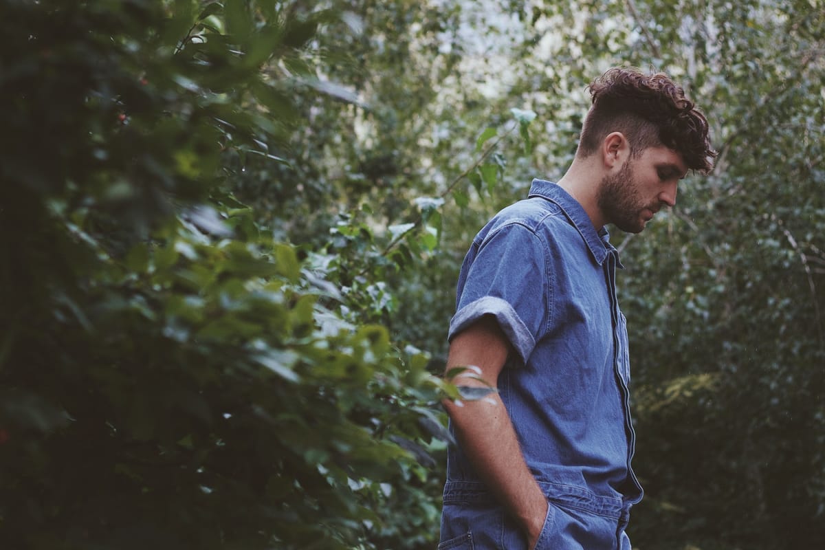man in bushes sad