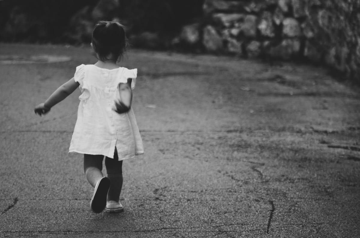 little girl running in street