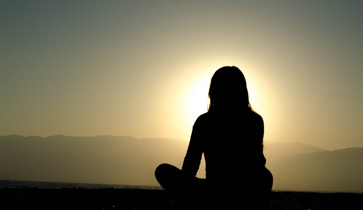 woman sitting against sunset