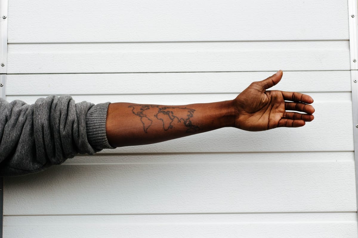 man with arm out world tattoo