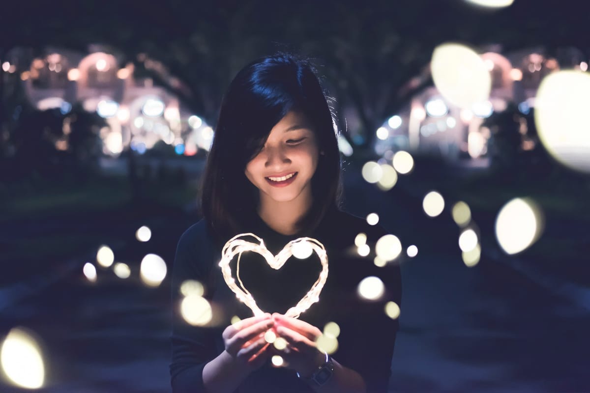 woman holding heart lights