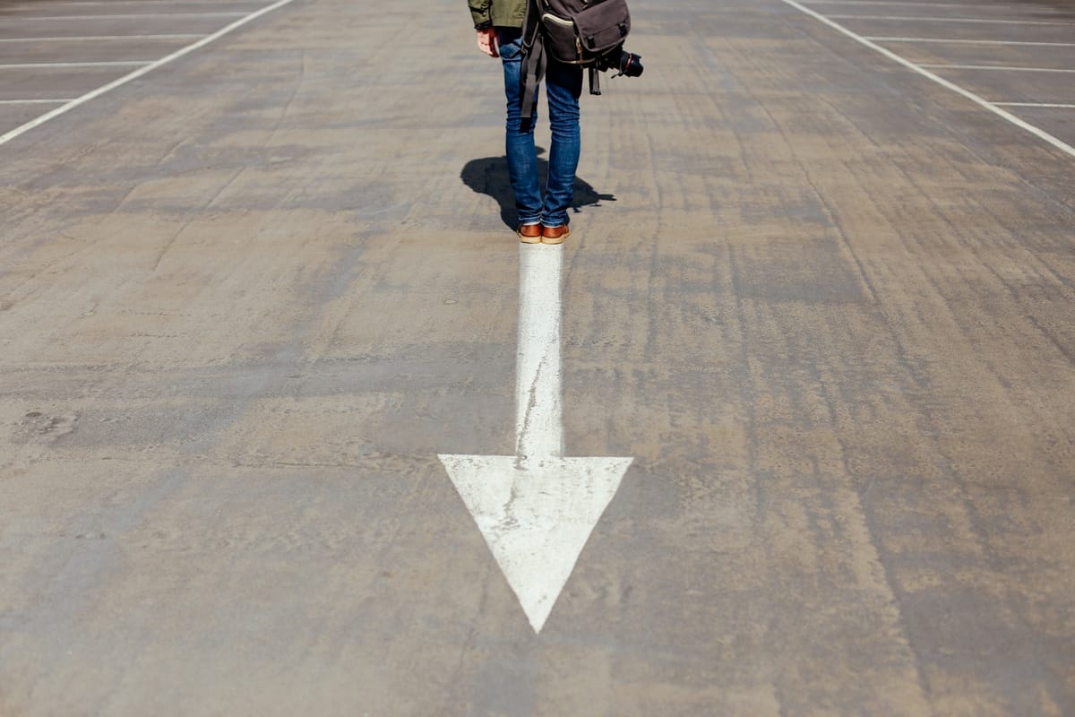 man standing on arrow