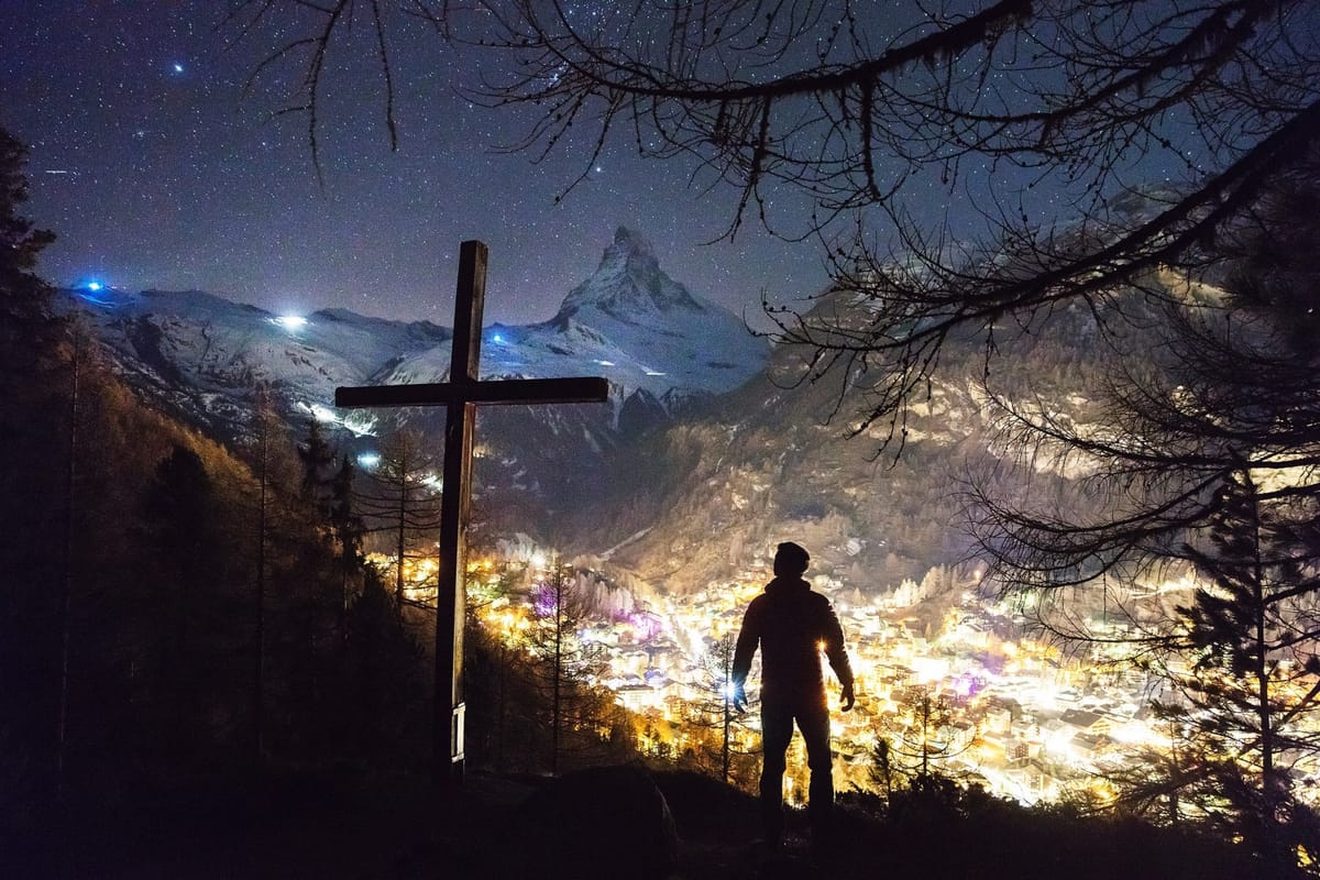 man on hill with cross