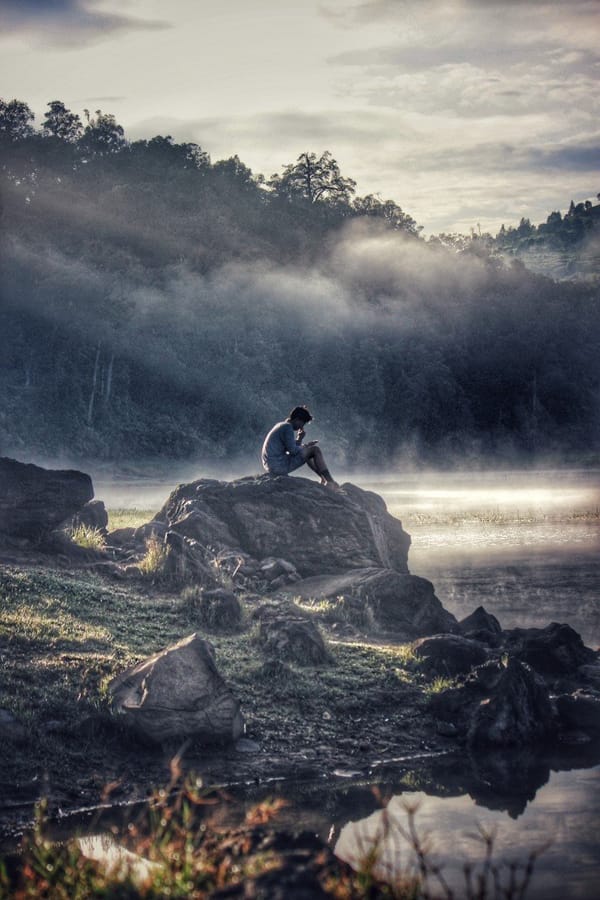 man sitting on rock