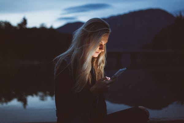 woman looking at phone in nature