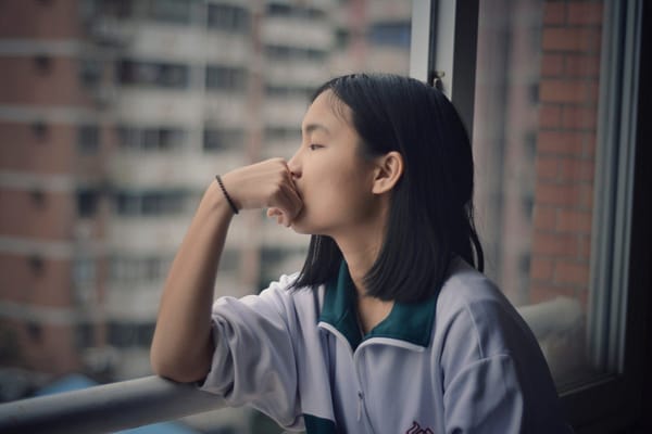 woman staring at windown with negative thoughts