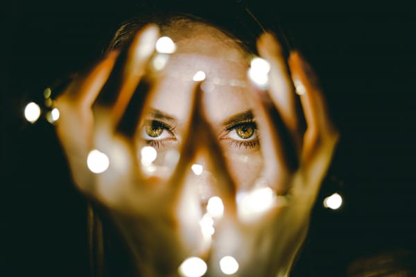 woman looking through christmas lights