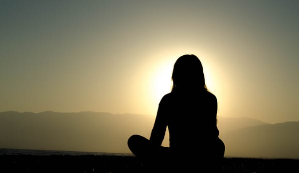 woman sitting against sunset