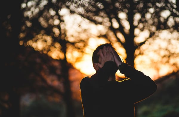 man with face in hands sad