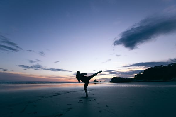 woman kickboxing on beach sunset
