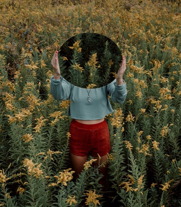 woman in field with mirror
