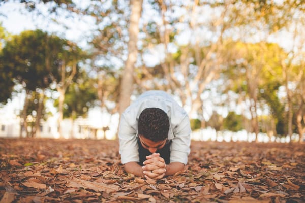man praying on knees