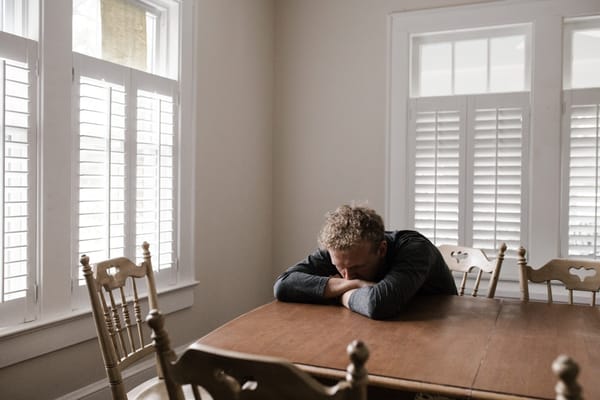 man with head down on table worrying what about tomorrow