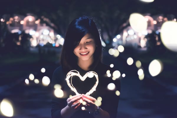 woman holding heart lights