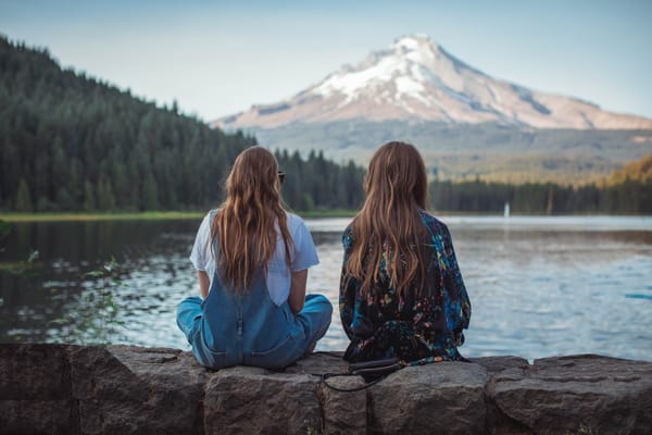 girls sitting mountain background