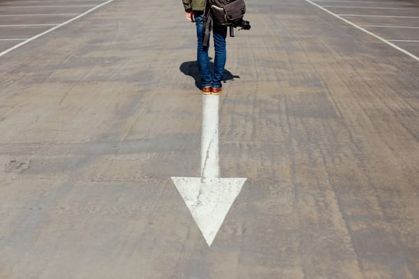 man standing on arrow